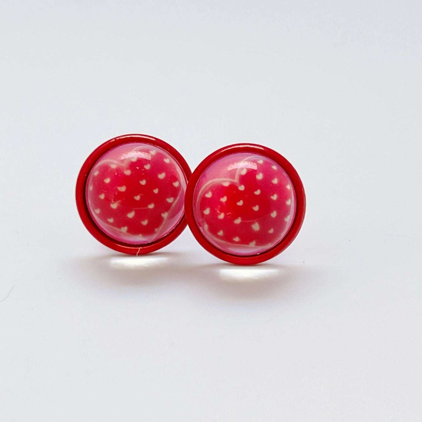 Red heart-shaped earrings on a white background
