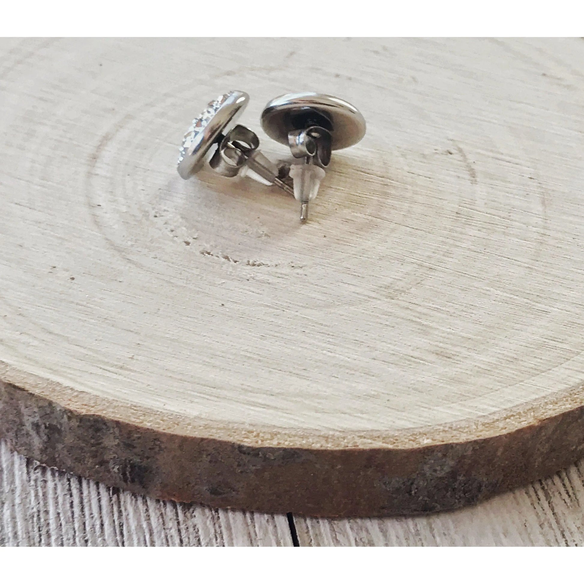 Back of silver stud earrings on a wooden surface