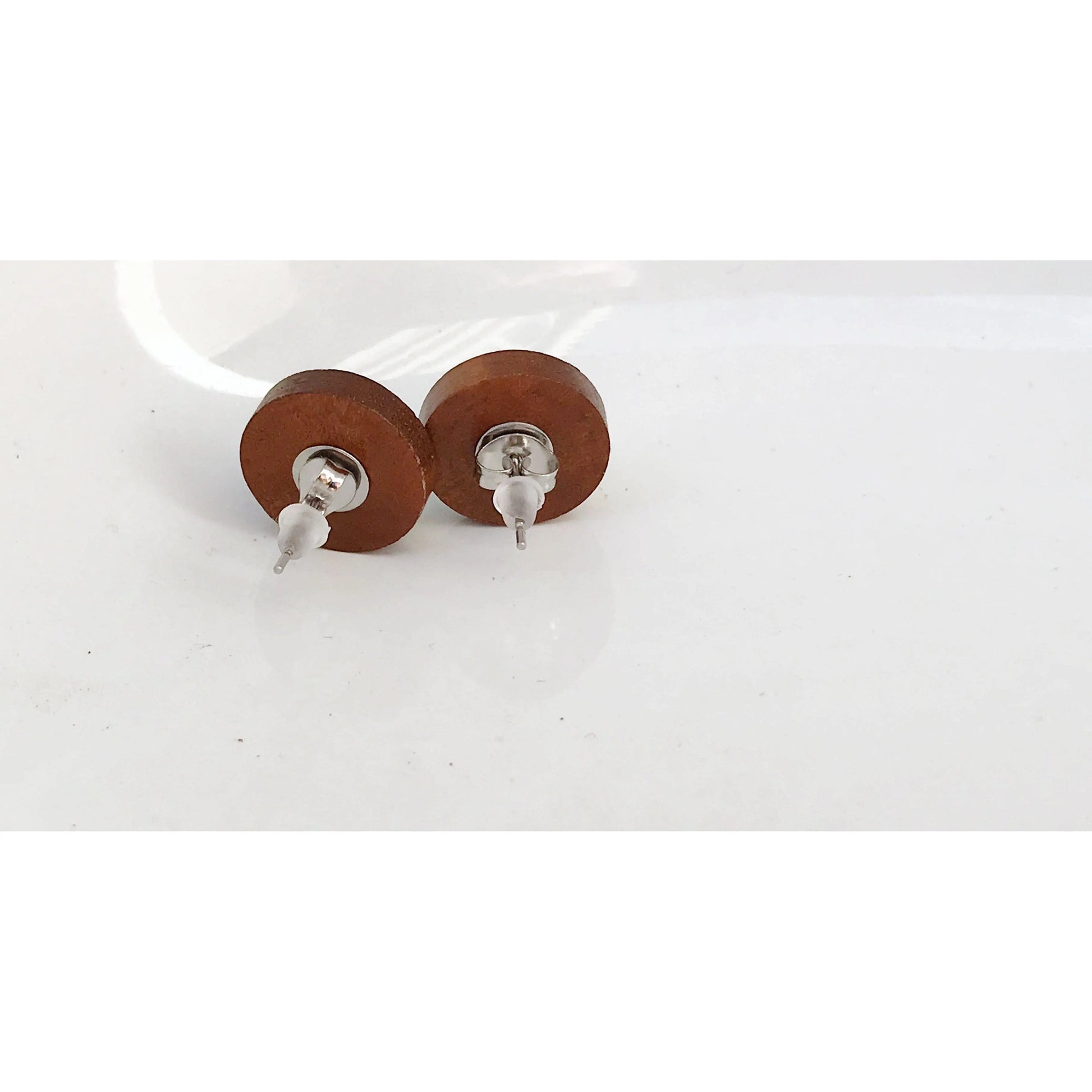 Back of round silver druzy wood stud earrings displayed on a white background