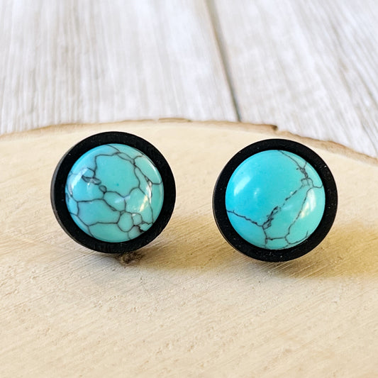 Black wood stud earrings with faux turquoise centers displayed on a wood background