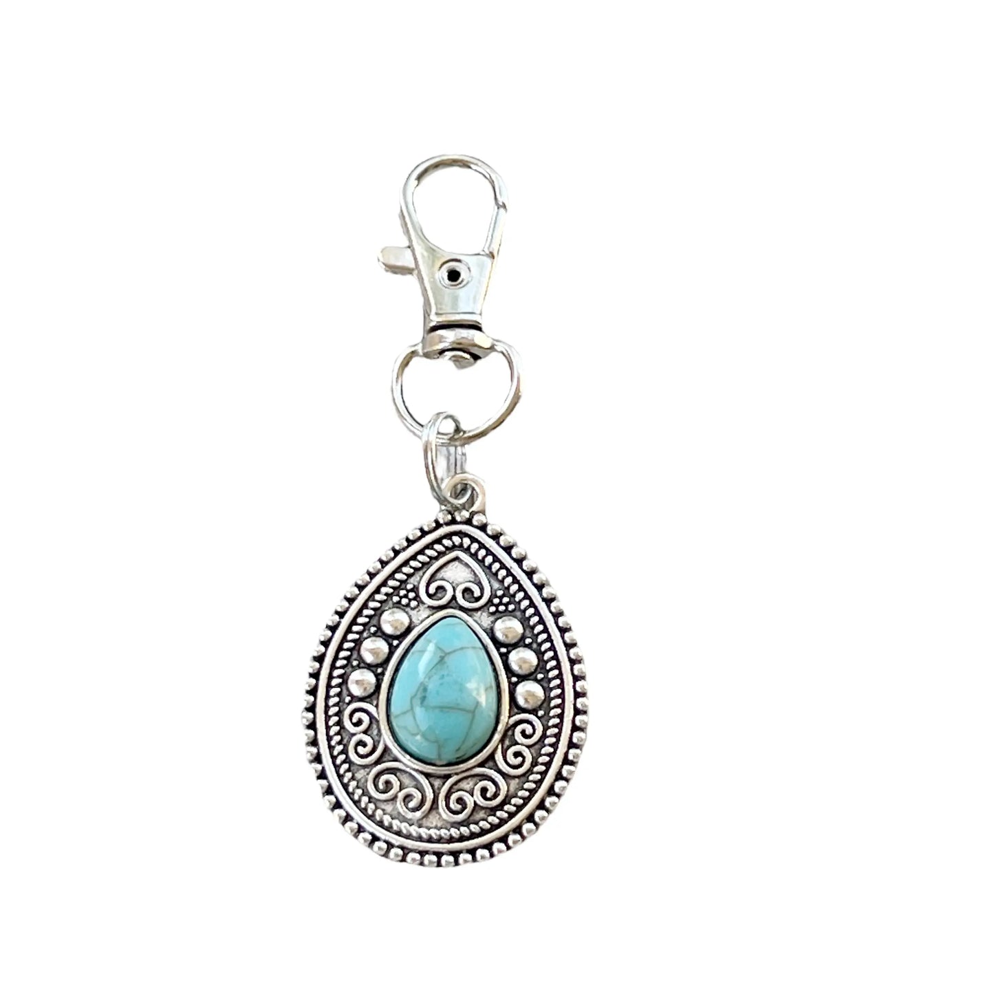 Silver western handbag charm with ornate medallion detail and faux turquoise accent on a white background 