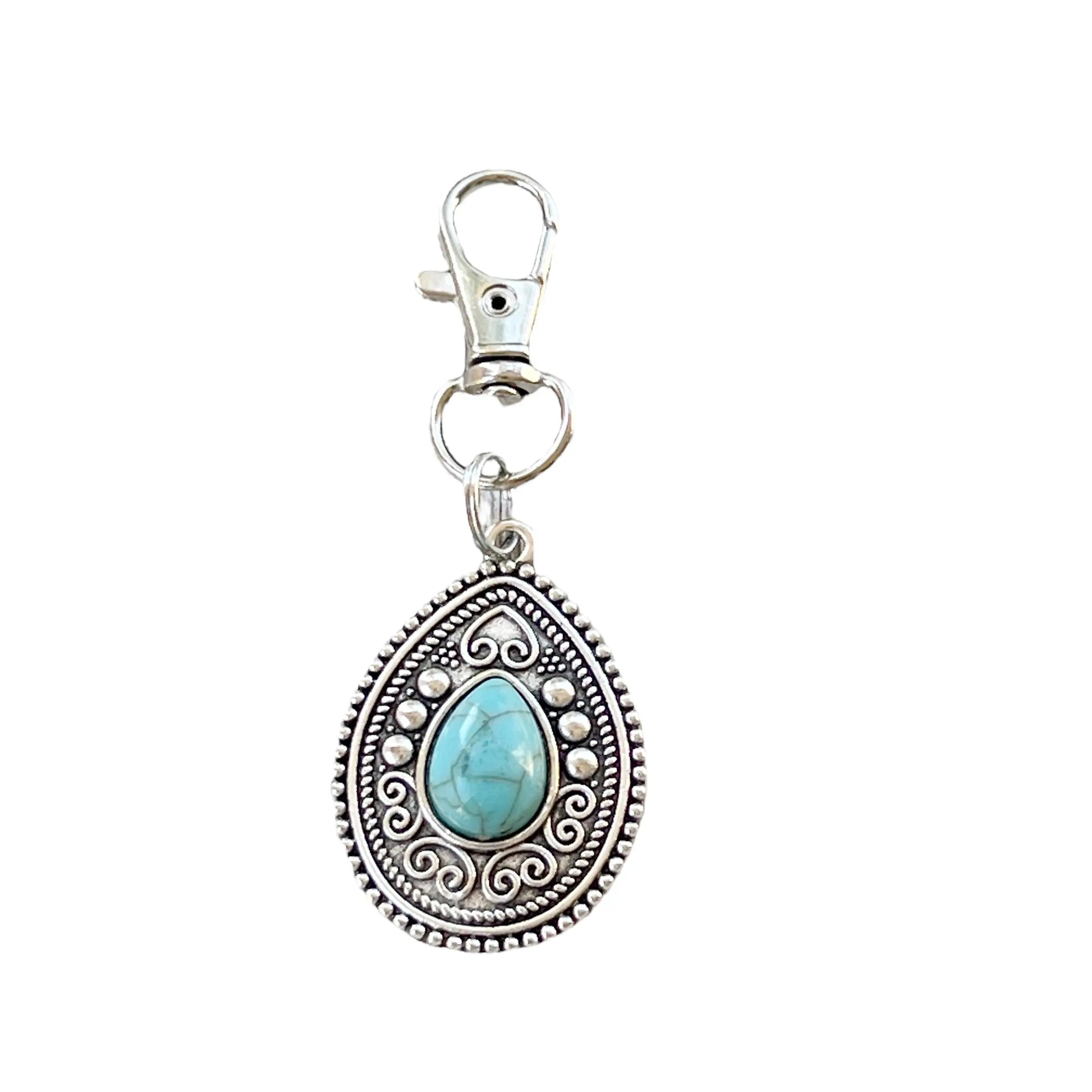 Silver western handbag charm with ornate medallion detail and faux turquoise accent on a white background 