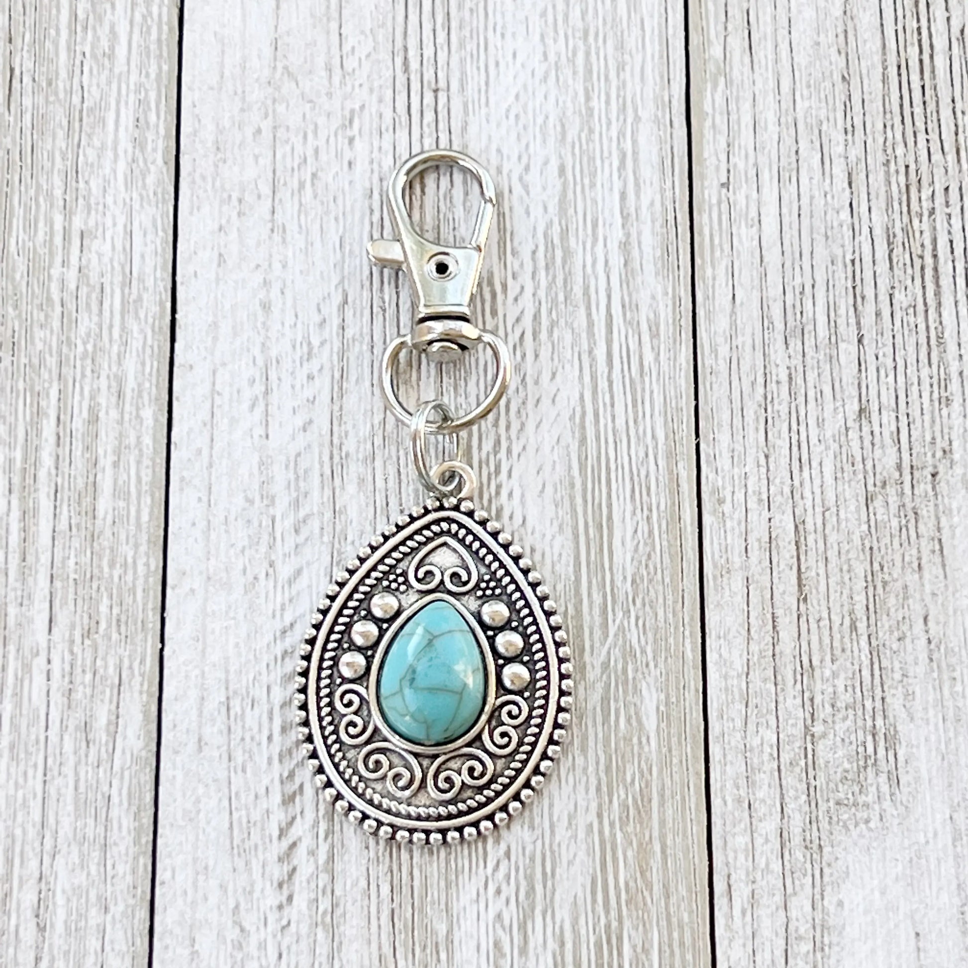 Silver western handbag charm full length view on wood tray