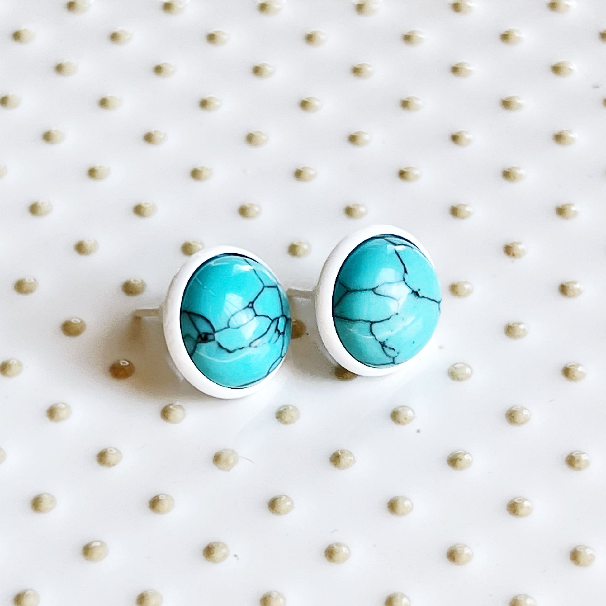 Round turquoise white stud earrings side view displayed on a light background