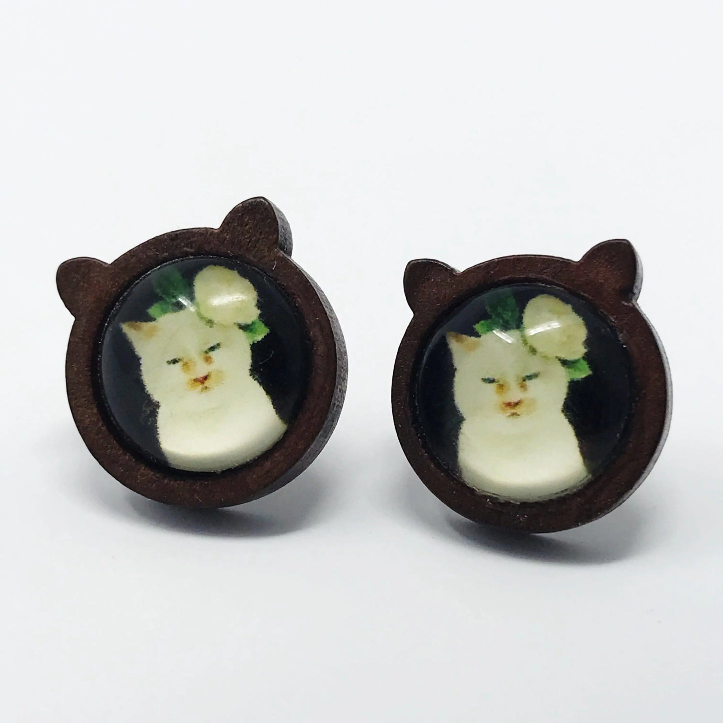 Pair of earrings with cat face design on a white background