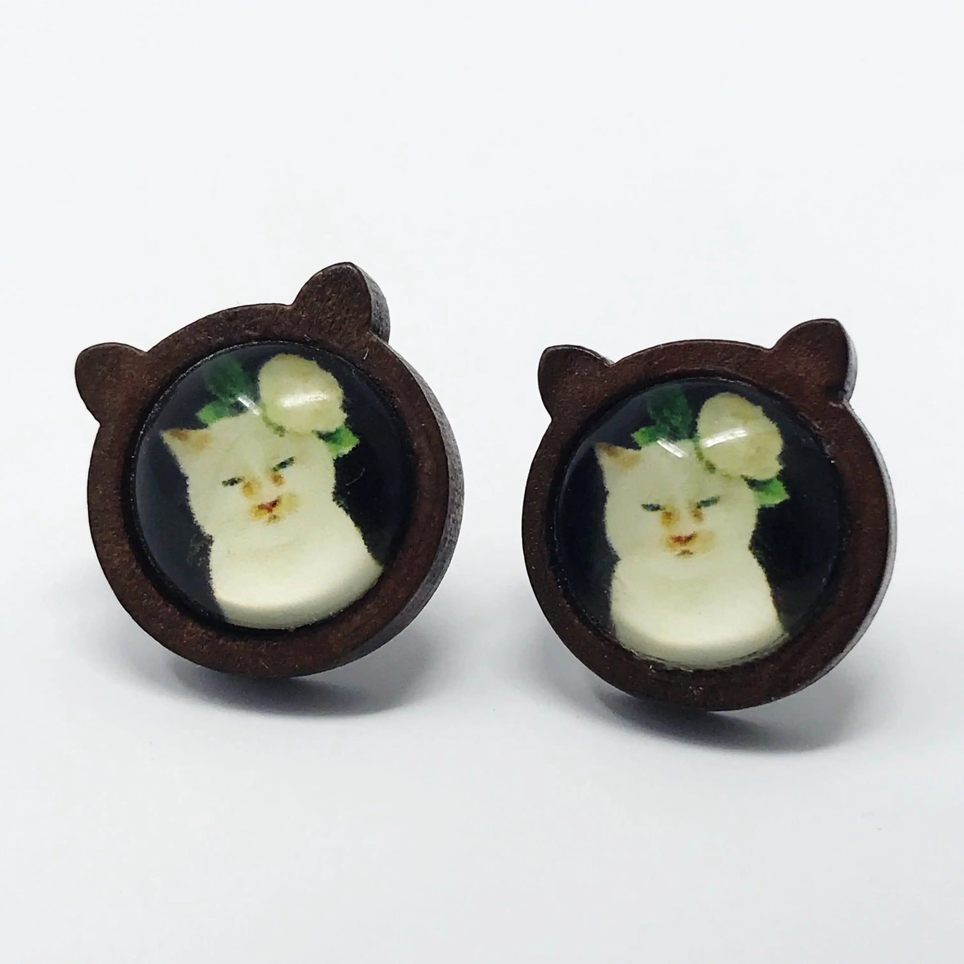 Pair of earrings with cat face design on a white background